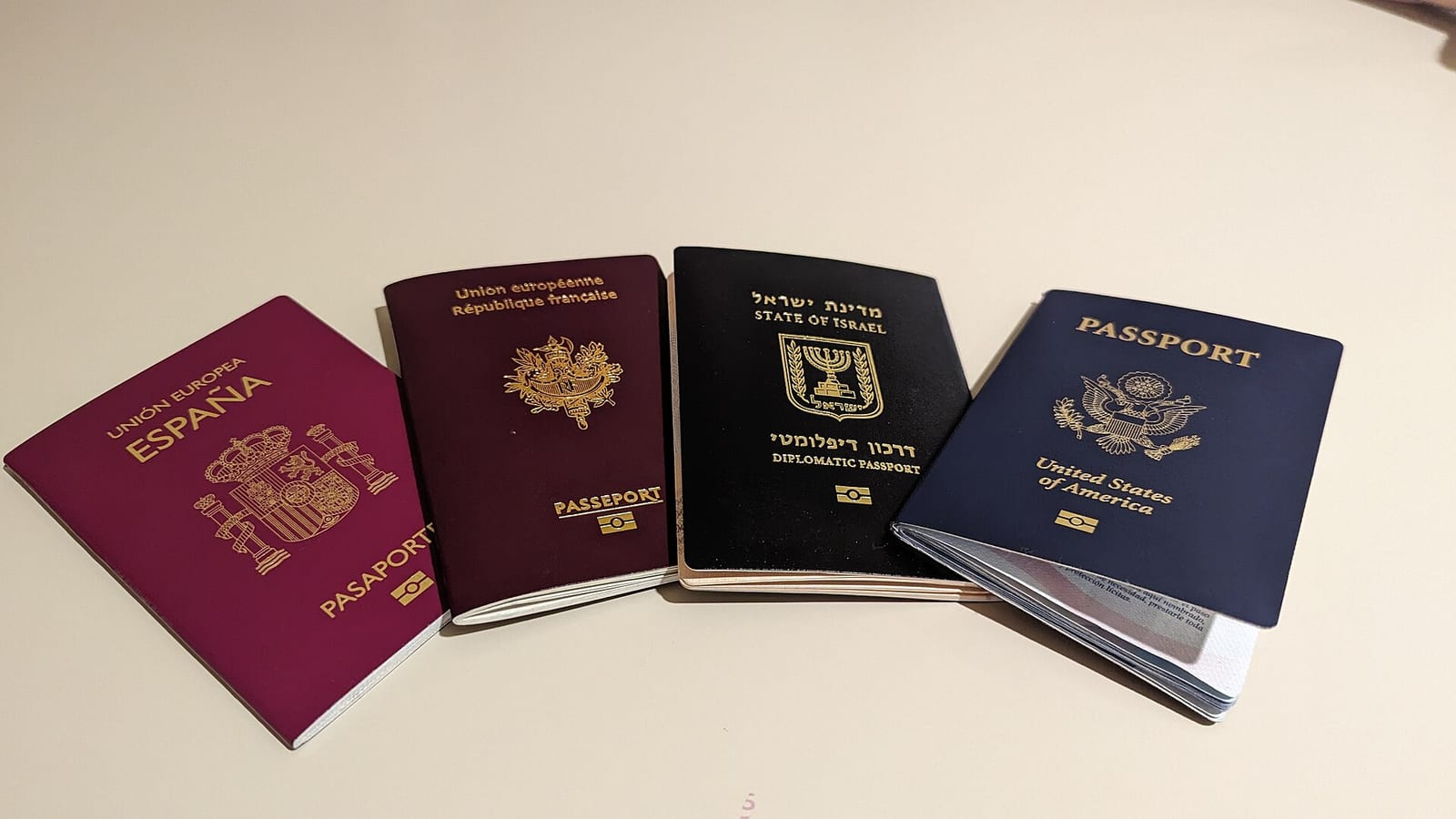 Quatre passeports posés sur une table, dont un passeport français